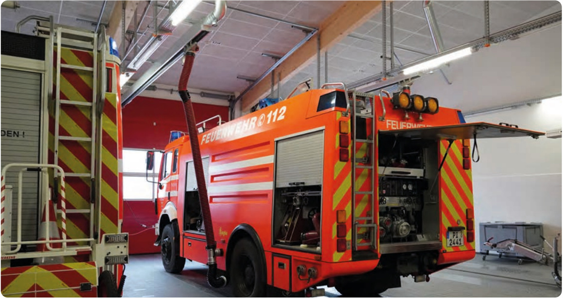 Feuerwehrfahrzeug mit Abgas-Absauganlage in einer Fahrzeughalle